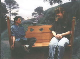 Eugene, sitting on a bench in Hobbiton with his wife, Carrie